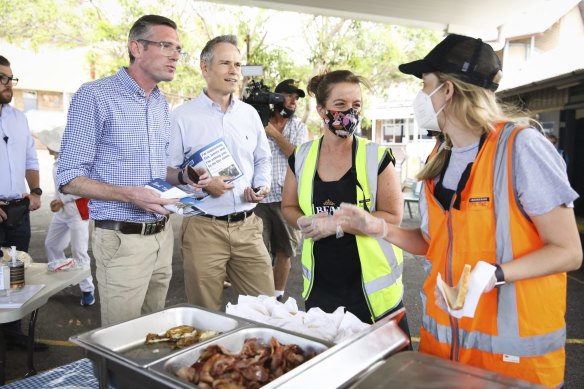 NSW Premier Dominic Perrottet and local candidate Tim James check out the Cammeray Public School sausage sizzle during the Willoughby byelection.