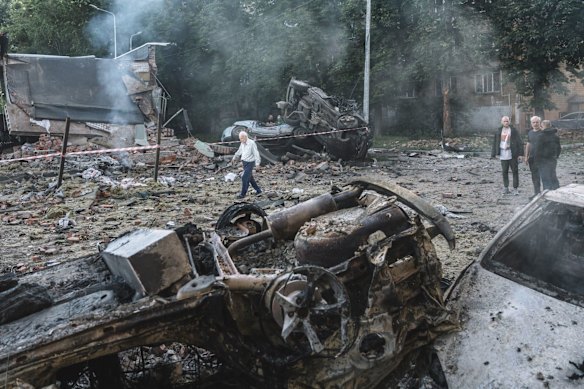Os moradores inspecionam o dano após um ataque aéreo russo em Kyiv.
