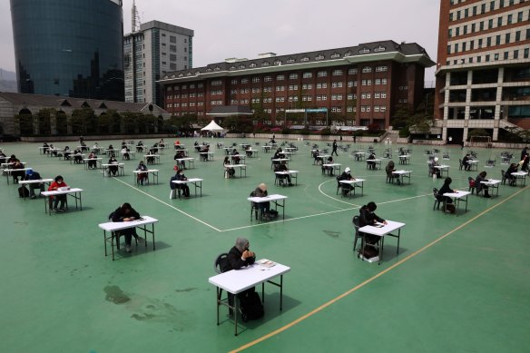South Koreans wear masks and sit according to social distancing as a preventive measure against the coronavirus during an exam.