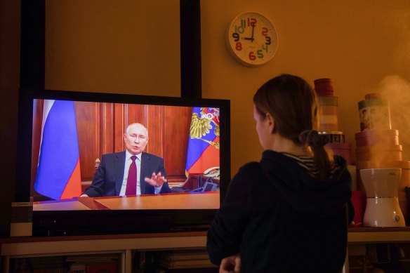 A resident watches a live broadcast of Vladimir Putin, Russia’s President, as he delivers an address, on a television in Moscow, Russia, on Monday, Feb. 22, 2022. 