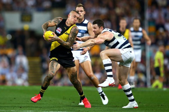 Richmond’s Dustin Martin slips past Patrick Dangerfield in the 2020 grand final.