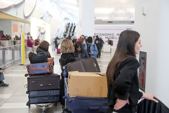 Travellers wait to check in at LaGuardia Airport in New York.