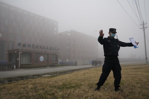 A security person moves journalists away from the Wuhan Institute of Virology after the WHO team arrived in February. 