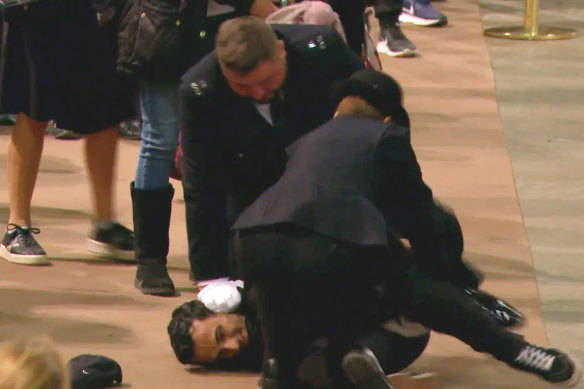 A screen grab of police restraining the man.