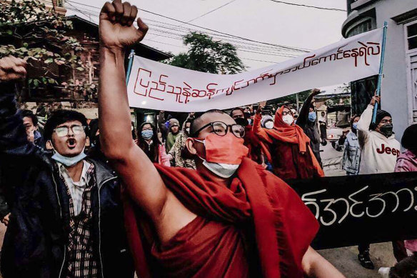 A Buddhist monk raises his clenched fist while marching during an anti-military government protest rally on February 1, 2022, in Mandalay, Myanmar. 
