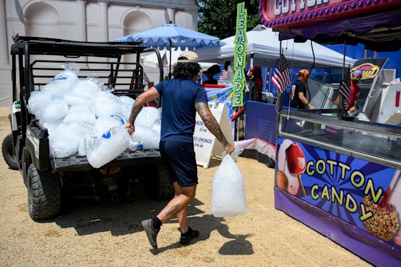 Un lavoratore sposta pacchi di ghiaccio durante le alte temperature alla Great American State Fair il 4 luglio.