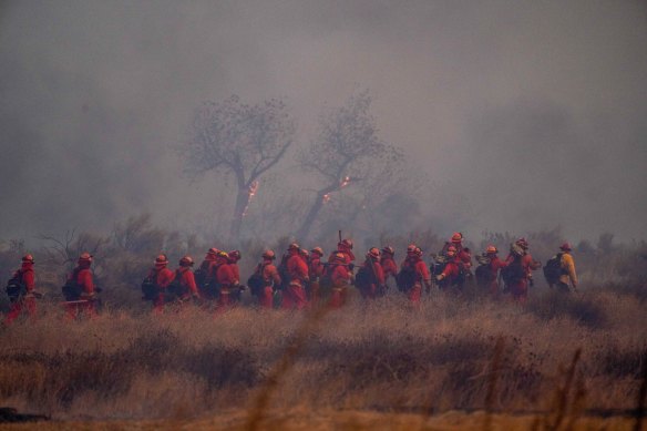 A crew of inmate firefighters begins to work on containment during the Hughes Fire.