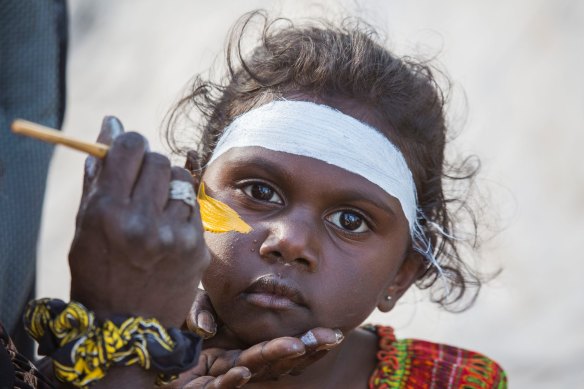 A Gumatj girl being painted in traditional colours for bunngul (ceremonial dances) at Garma in north-east Arnhem Land. 