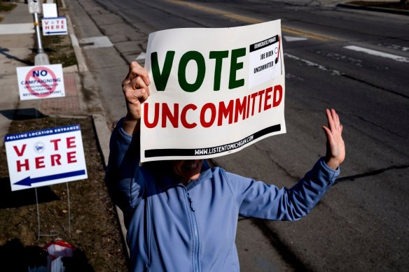 A volunteer holds a sign outside a polling station at Oakman School in Dearborn, Michigan.