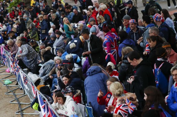 People gather at The Mall to watch the coronation procession.