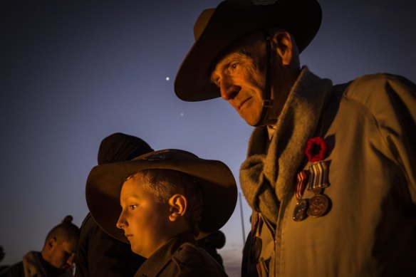 Hayden Doughty, 10, pays his respects at the Shrine of Remembrance alongside John Murphy.