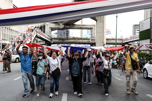 Protesters hold a giant Thai flag during a demonstration in Bangkok on Saturday to demand Shinawatra’s resignation.