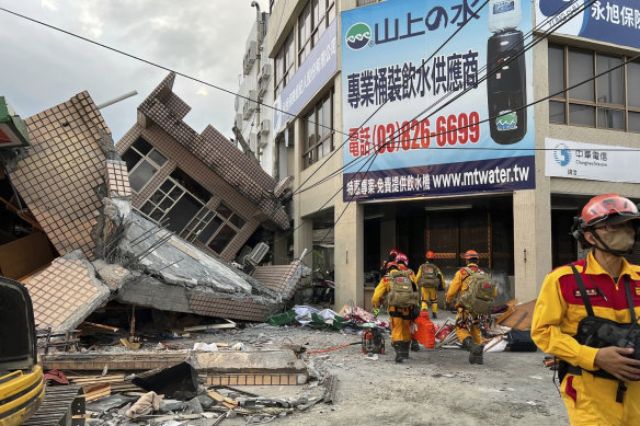 Firefighters search for trapped victims in a collapsed residential building following earthquake in Yuli township in Hualien County.