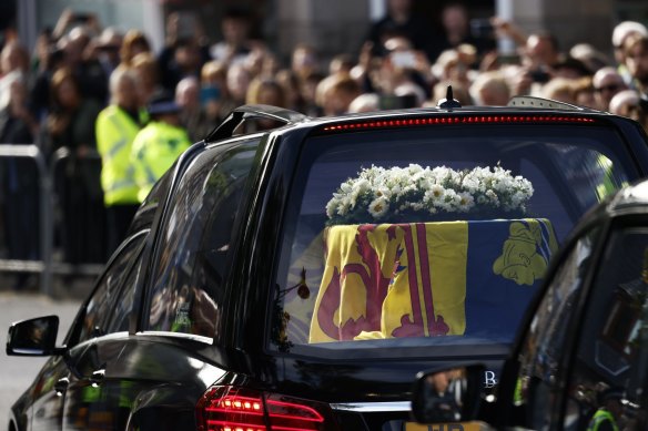 Crowds watch as the cortege carrying the coffin of the late Queen Elizabeth II passes by.