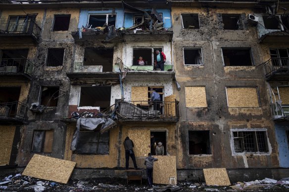 Residents close the windows of an apartment building with plywood after Russian shelling in Dobropillya, Donetsk region, eastern Ukraine on Saturday. 