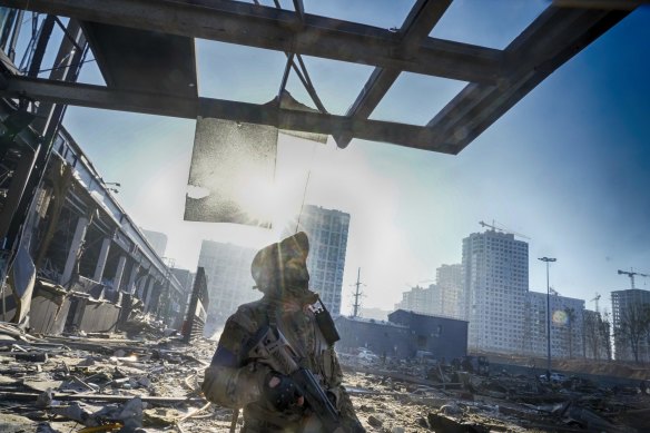 A Ukrainian soldier stands on the ruins after Russian shelling destroyed a shopping center in Kyiv.