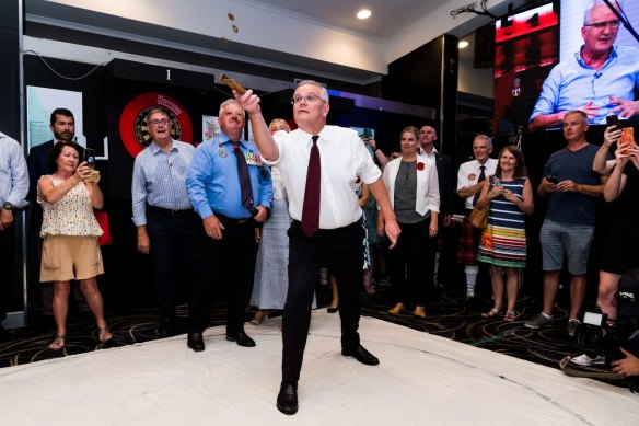 Then-prime minister Scott Morrison plays two-up at Cazalys Palmerston Club on Anzac Day last year.