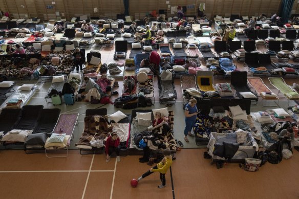 People who fled the war in Ukraine rest inside an indoor sports stadium being used as a refugee center, in the village of Medyka, a border crossing between Poland and Ukraine.