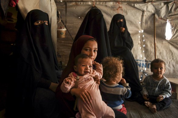 Australian Maysa Assaad, 9, holding Shayma Assaada's daughter Mariam (second from left) in the al-Hawl camp.