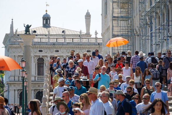 Tourists on the Ponte della Paglia historic footbridge in Venice in June.
