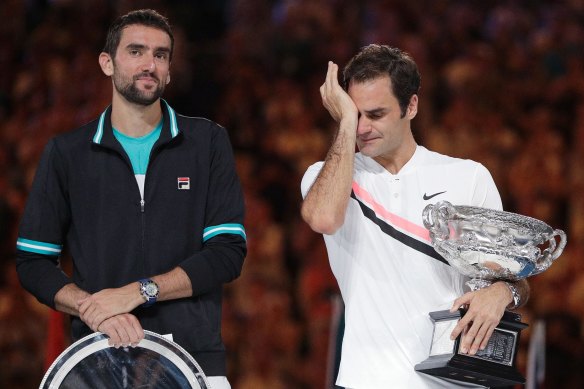 Roger Federer wipes away tears after defeating Croatia's Marin Cilic, left, to win the Australian Open and achieve a grand slam record in 2018. 