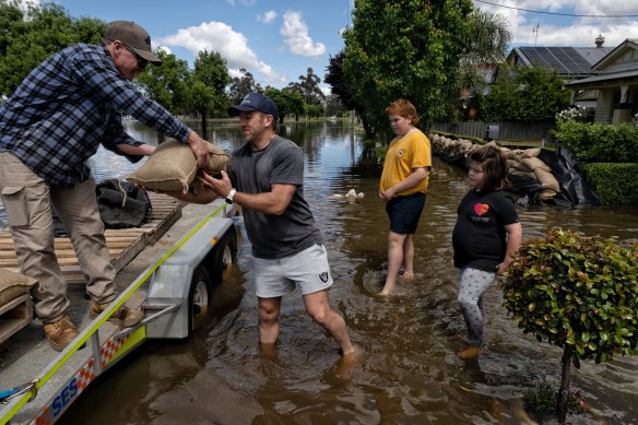 Justin Walker grabs some extra sandbags as flooding enters the Forbes township. 