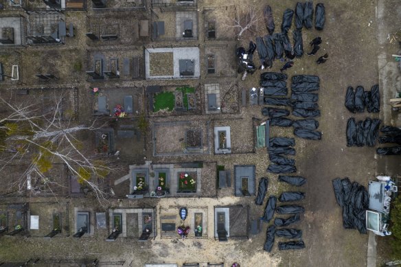 Policemen work to identify civilians who were killed during the Russian occupation in Bucha, Ukraine, on the outskirts of Kyiv, before sending the bodies to the morgue, Wednesday, April 6, 2022. (AP Photo/Rodrigo Abd)