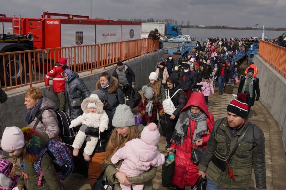 Ukranian refugees get off a ferry at the border crossing in Romania.
