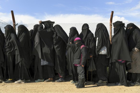 Foreign IS wives and children line up in the Al Hawl camp in Syria to be taken to shops in the camp in 2019.