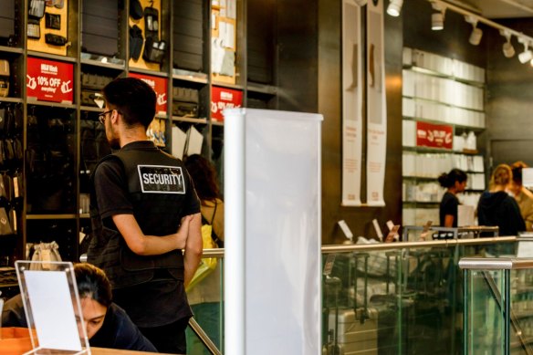 A security guard stands near the entrance of a shop in central London.