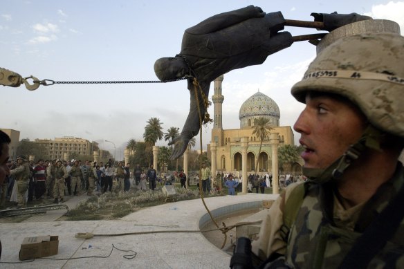 Iraqi civilians and US soldiers pull down a statue of Saddam Hussein in Baghdad in 2003.