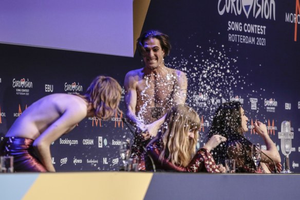 Damiano David, centre, sprays champagne onto Thomas Raggi, from left, Victoria De Angelisa and Ethan Torchio at the press conference after their band Maneskin from Italy won Eurovision.