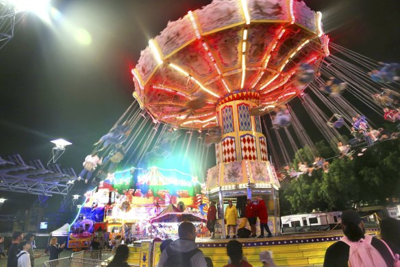 Patrons take in the evening sounds and colours of the Royal Easter Show. 