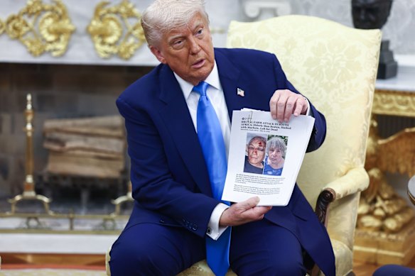 President Donald Trump held up print-outs of stories about white farmers who were victims of crime, and handed them to the South African leader.