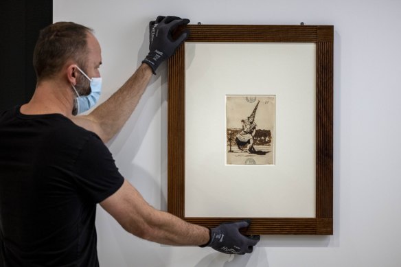 A Goya drawing being hung at the NGV.