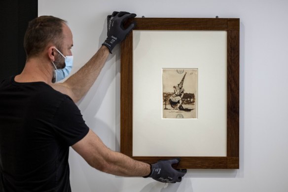 A Goya drawing being hung at the NGV.