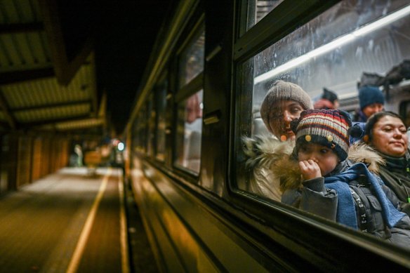 A woman and a child wait for a call to cross the passport control after arriving from Kyiv in Przemysl, Poland.