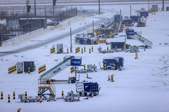 Equipment to be used by aircraft  operated by Ryanair Holdings wait on the snow-covered tarmac at London Stansted Airport on Monday.