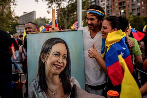 Residents takes a photograph near a painting of Venezuelan opposition leader Maria Corina Machado during a celebration in Santiago, Chile.