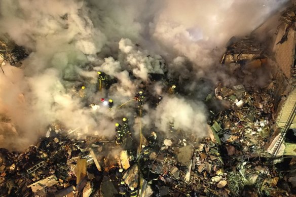 Emergency workers clear the rubble after a Russian rocket hitthe multistory building in the city of Dnipro.