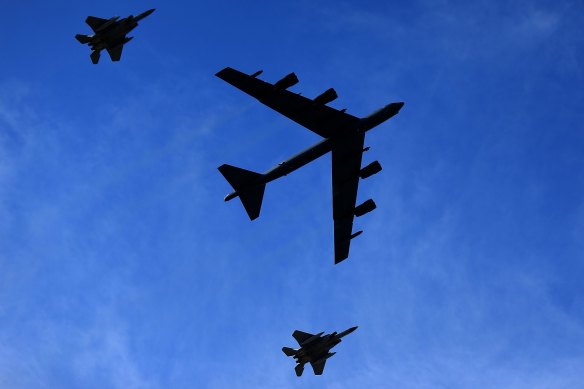 A Boeing B-52 Stratofortress is escorted by two McDonnell Douglas F-15 Eagles.