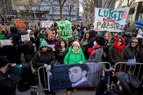 Luigi Mangione supporters hold signs outside New York Supreme Court in February.