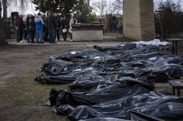 Dozens of black bags containing more bodies of victims at a cemetery in Bucha in April. Putin said the alleged atrocities were “fake”.