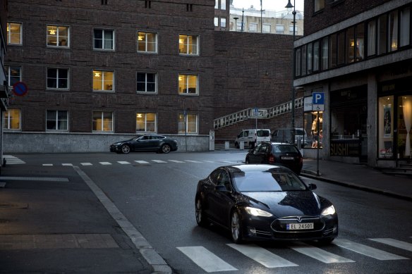 A Tesla Model S electric vehicle (EV) drives past the city hall in Oslo, Norway, in 2016. 