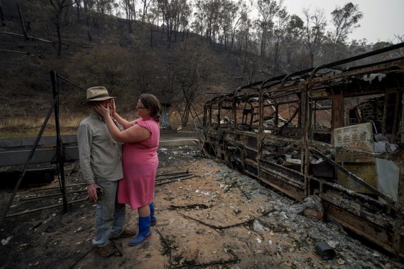 Mark Brooks and his daughter Kylee in front of the burnt out property in January last year.
