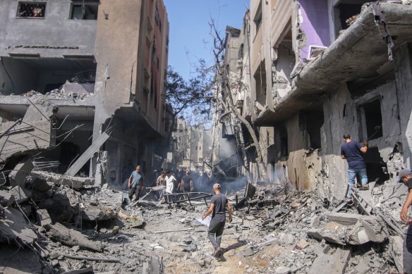 Palestinians at the site of an Israeli strike on buildings in Nuseirat refugee camp during the hostage rescue.