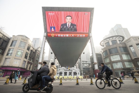 A screen displays a news broadcast of Li Keqiang, China’s premier, during the opening of the First Session of the 14th National People’s Congress (NPC) at the Great Hall of the People in Beijing.