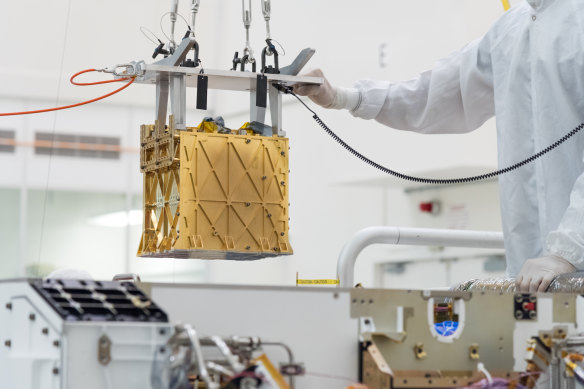 The Mars Oxygen In-Situ Resource Utilisation Experiment (MOXIE) developed by NASA is carefully lowered into the belly of the Perseverance rover