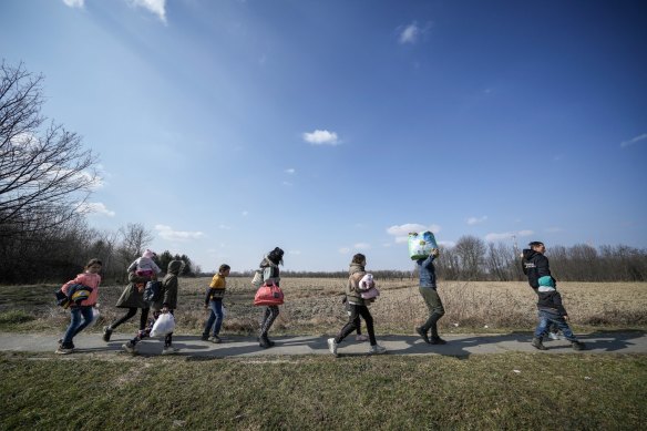 Refugees fleeing Ukraine walk through the Hungarian countryside near Tiszabecs.