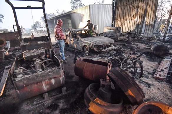 Peter Riley (left) and his son-in-law Simon Evvage inspect their fire-damaged Clifton Creek property. 